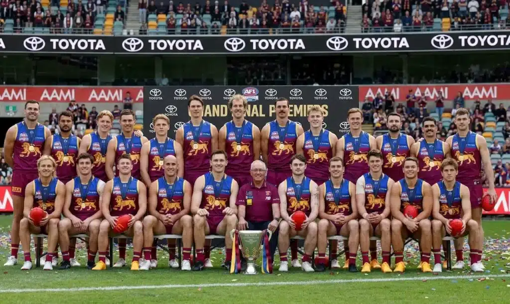 Brisbane Lions Players and Coach Lined Up Together with Their Trophy 